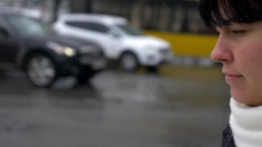 Üzgün esmer kadın kar yağışı sırasında şehir sokak üzerinde yürür. Yavaş hareket su saç bırakır. Kış