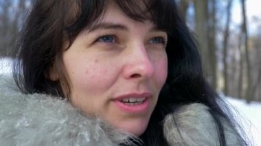 Güzel esmer kız gülümsüyor ve puan parmak olağanüstü bir şey. Kışın kar ağır çekim