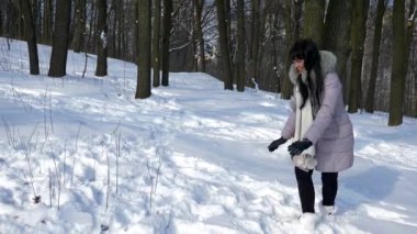 Güzel esmer kız gülümseyerek kartopu atar. Mutlu olumlu duygu kış kar ağır çekim