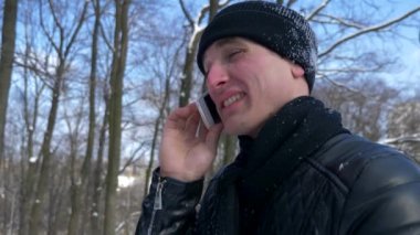 Konuşmak Smartphone yakışıklı delikanlı. Ağır çekim kış güneşli gün