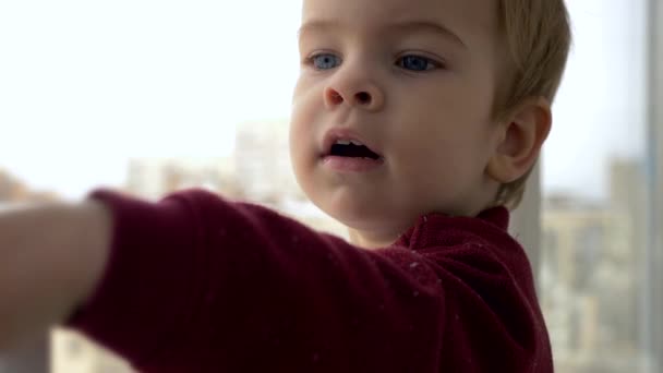 小さな子供は立っているし ウィンドウに見えます 触れる濡れたガラス 遅いモーション冬市 — ストック動画