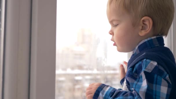 Carino Bambino Guardando Nella Finestra Bagnato Puntando Dito Città Invernale — Video Stock