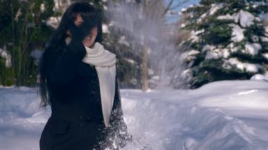 Mutlu güzel kız kar hava atar. Kar Park kaplı. Kış şehir hayatı. Ağır çekim 30 fps 1/2 gerçek zamanlı hız 60 fps