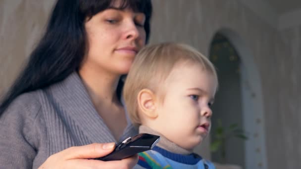 Krásná Matka Dálkovým Ovládáním Ruce Roztomilé Dítě Sledoval Osobní Domácí — Stock video