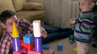 Mutlu baba bina Oyuncak kale. Bozma ve odasında oyuncak tuğla atma çocuk. Ağır çekim 30p 0,5 gerçek zamanlı hız 60p