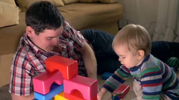 Feliz Padre Hijo Construyen Estructura Usando Ladrillos Juguete Habitación Felices — Vídeos de Stock