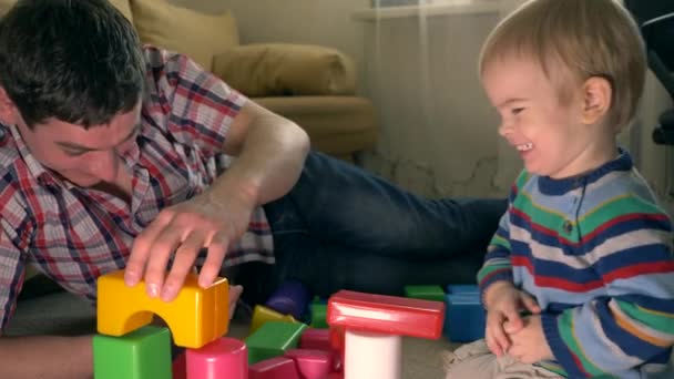 Счастливый Отец Сын Строят Структуру Используя Игрушечные Кирпичи Комнате Счастливых — стоковое видео