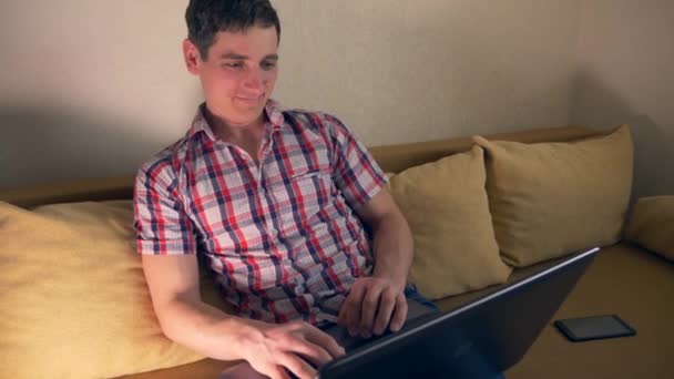 Jovem Usando Laptop Surfing Internet Senta Sofá Sofá Movimento Lento — Vídeo de Stock