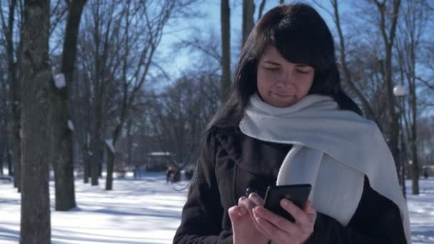 60P Glücklich Lächelnde Schöne Frau Mit Smartphone Sonniger Tag Verschneiten — Stockvideo
