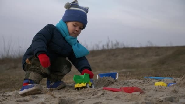 Симпатичный Ребенок Играет Одиночку Игрушечными Грузовиками Автомобилей Песчаном Пляже Ривер — стоковое видео