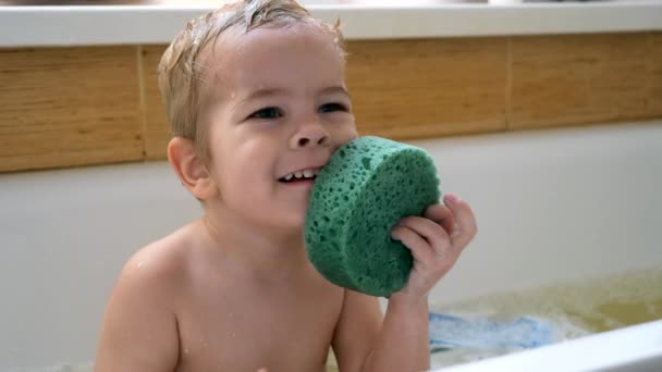 ハッピーかわいい子供はバスタブのシャンプーとウォッシュクロスで自分自身を洗います 浴室内のお風呂 スローモーション0 5速度60 Fps — ストック動画