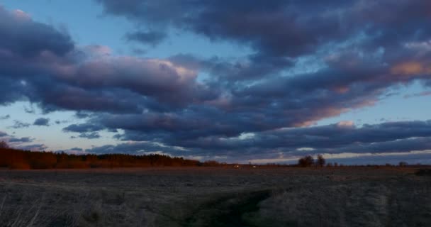 夜の雲の景色グローブの農村道路の近くの川の上の夕日 田舎の風景日木を通して輝きます 劇的な雲が吹く風 季節変更秋冬の春時間 夕方オレンジ Blue Sky — ストック動画