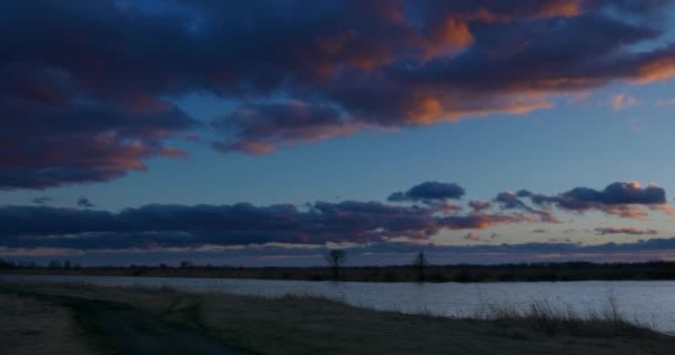 川の上の日没前の男釣り 家族の休暇旅行で車で 自然をテーマにしたカップル 田舎の風景の上の夕方の雲 劇的な雲が吹く風 季節変更秋冬の春時間 Blue Sky — ストック動画