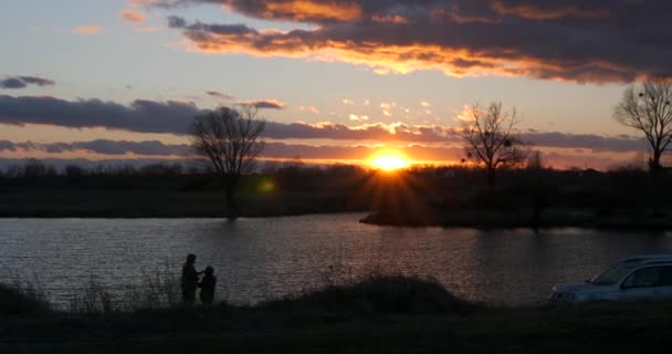 Hombre Pesca Frente Puesta Del Sol Sobre Río Familia Vacaciones — Vídeo de stock