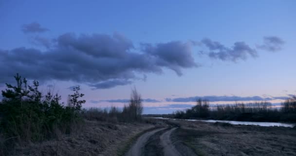 全景黄昏多云的天空在乡间小河畔的乡间小道上 春秋时分 — 图库视频影像