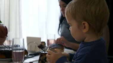 Tatlı Çocuk Vegan Çikolatalı Kirazlı Turta Yiyiyor. Sağlıklı yiyecekler. Bulanık Arkaplanda Genç Anne İçme Komplosu. Yavaş çekim 0. 5 hız 60 fps