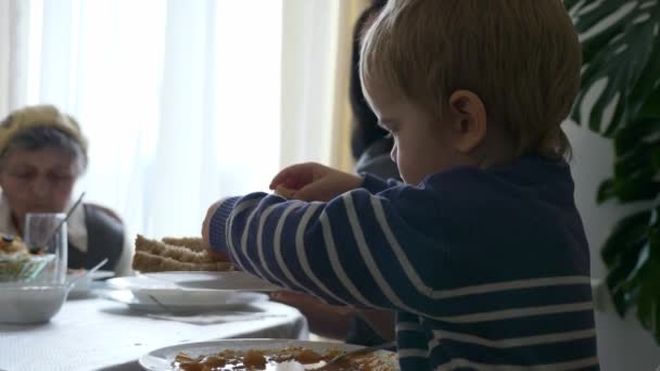 小さな子供はパンを取り スープに追加します 食事を楽しむディナーを持つ多世代の家族 スローモーション0 5速度60 Fps — ストック動画
