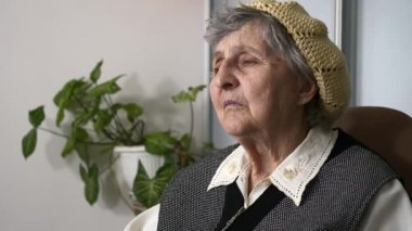 Yaşlı, üzgün, yaşlı bir kadının portresi. Yaşlı, büyük büyükannenin hayatı hakkında düşünmesi. Koltukta sakin oturması hakkında. Yavaş çekim 0. 5 hız