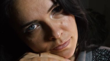 Dolly 'nin yakın çekimi dramatik genç bayan yüzü. Ciddi, sakin, duygusal ev hanımı karanlık odada otururken düşünüyor.