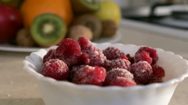 Mutfak tezgahında yakın plan donmuş ahududu. Pencereden Sabah Akşamı Güneşi. 2x Yavaş çekim, 0.5 hız 60 FPS