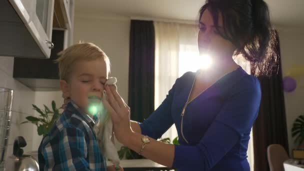 사랑많은 어머니는 아들의 얼굴을 수건으로 닦는다 카운터에 애무하는 창문으로 비치는 — 비디오
