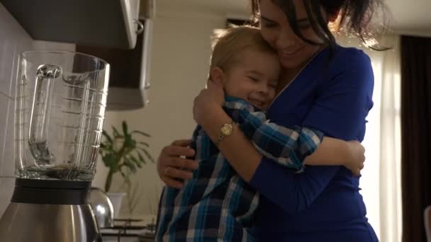 Loving Mother Hugs Little Son Woman Embracing Child Sitting Kitchen — Stock Video