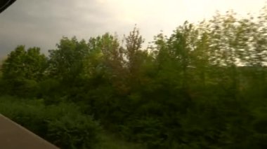 Tren vagonunun manzarası pencereyi açtı. Avrupa 'yı boydan boya geçen bir tren yolculuğu. Trees Fields Village Akşam Manzarası. Yaz Sonbahar Sezonu,