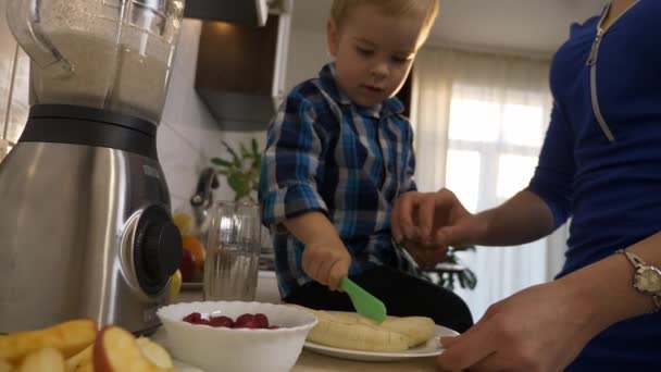 Kisfiú Segít Anyának Ételt Készíteni Ételhez Child Cuts Banánszeletet Készít — Stock videók