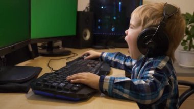 Yorgun Çocuk, internette sörf yaparken esneyerek bilgisayar kullanmayı öğreniyor. Çocuk Yeşil Ekran Ekranlarının Önünde Oturuyor. PC Çalışma İstasyonu. Oyun bilgisayarı.
