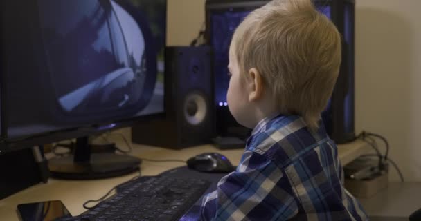 Serious Little Child Watching Cars Driving Videos Games Computer Monitor — Stockvideo