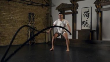 Savaş halatlarıyla yoğun antrenman. Profesyonel Dövüş Sanatları Boksörü Sıkı Gerilim Eğitimi Duygusu. Doğu Asya Style Studio 'da atlet. Japonca 