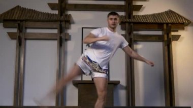 Profesyonel Dövüş Sanatları Dövüşçüleri Tekmeleri Çalışıyor. Sporcu Eğitimi Dövüş için Hazırlanıyor. Ortam yumuşuyor. Profesyonel Sporcu Yarışmaya Hazırlanıyor. Doğu Asya Style Studio 'da Atletizm Eğitimi.