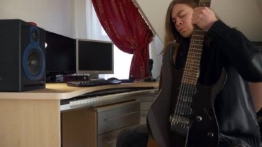 Gitarın tozunu silen adam. Genç Yetişkin Müzisyen Rocker Ev Stüdyosunda Enstrümanı Önemsiyor. 2x Yavaş çekim 0.5 hız 4K 60p