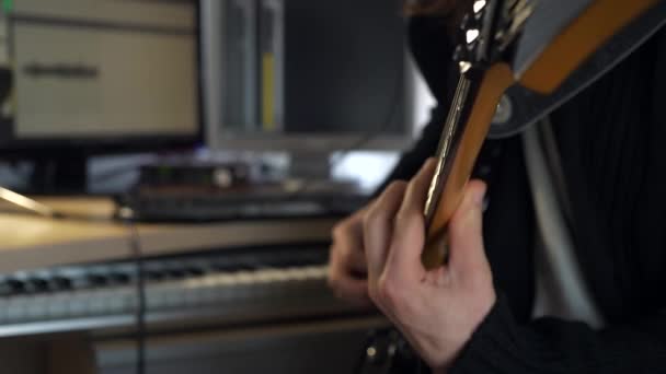 フリーボードの弦の上の指 エレクトリック ギターで演奏するクローズアップ ハンズ ホーム スタジオでは 若い成人音楽家が演奏と録音を行う 2倍スローモーション0 5速度4K 60P — ストック動画