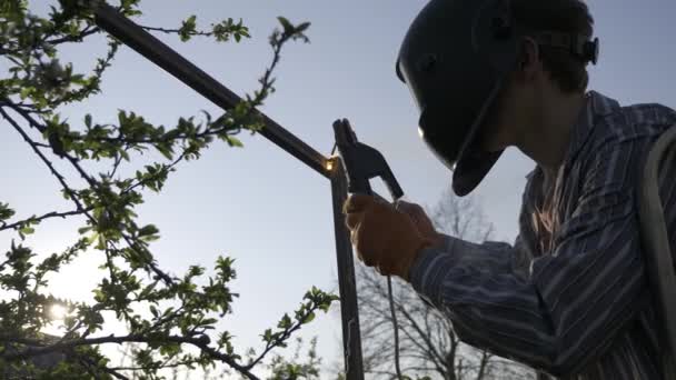 Jongeman Lassen Metalen Bouw Achtertuin Werknemer Beschermende Helm Tuin Buurt — Stockvideo