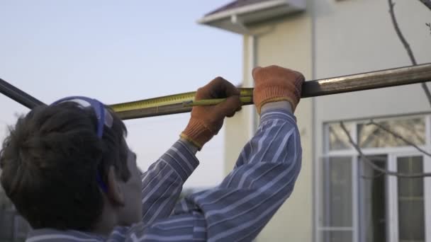 Jovem Medição Com Instrumento Medição Fita Desenha Marcas Com Lápis — Vídeo de Stock