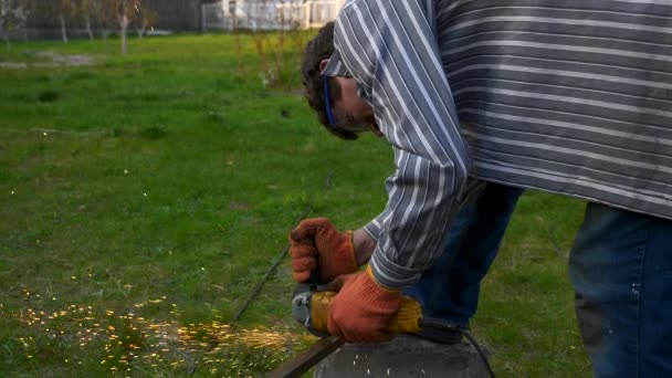 Junger Mann Schneidet Eisen Metallkonstruktion Mit Winkelschleifer Auf Hinterhof Garten — Stockvideo