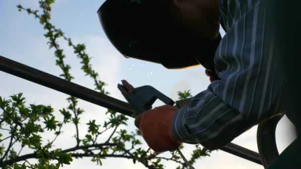 Young Man Welding Metal Construction Backyard Worker Protective Helmet Garden — Stock Video