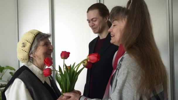 Mature Daughter Young Adult Grandson Visit Give Present Tulip Flowers — Stock Video