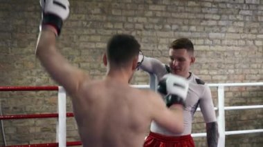 Muay Thai Boksörü Boks ringinde Diz üstü Zıplayan Hava Tekmeleri yapıyor. Kafkas Adam, Şehir Spor Salonu 'nda Dövüş Sanatları Eğitmenliği yapıyor. 2x Yavaş çekim 1 / 2 hız 60 fps 4K