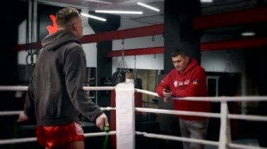 Boksör, Şehir Spor Salonu 'nda Boks ringinde Koç Eğitmeniyle İp Atlama Eğitimi yapıyor. Sporcu Dövüş Sanatları Sporu. Yavaş çekim