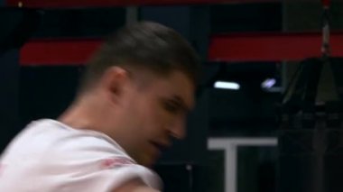 Muay Thai Boksör Tekme ve Yumruk Torbası. Beyaz Adam Şehir Spor Salonu 'nda eğitim görüyor. 2x Yavaş çekim 1 / 2 hız 60 fps 4K