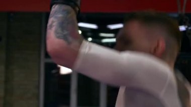 Muay Thai boksörüne yakın çekim, pedlere tekme ve yumruk pratiği. Spor salonunda koç ile boks ringinde antrenman yapıyorum. Sporcu Dövüş Sanatları Sporu