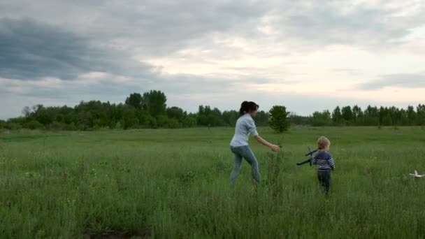 Familie Spielt Mit Spielzeugflugzeugen Grasfeld Glückliche Mutter Und Kinder Frühlingsabend — Stockvideo