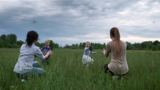 Szczęśliwe Dzieci Biegnij Wildflowers Dać Matce Wysoka Trawa Polu Wieczorna — Wideo stockowe