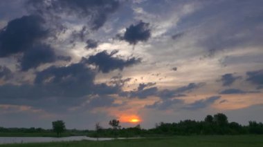 Saha Çayırı Nehir Ağaçları 'nın Üzerinde Güzel Günbatımı Gökyüzü. Bahar Gecesi Alacakaranlık Kırsal Sahne Manzarası. Dramatik Bulutlu Gökyüzü