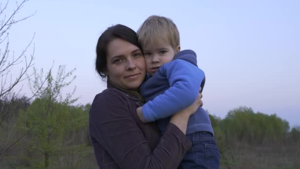 Porträt Schöne Liebende Mutter Umarmt Süßen Kleinen Sohn Frühlingsabend — Stockvideo