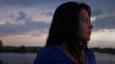 Güzel Kadın, Yağmur Altında Nehir ve Çayırda Gün Batımında Özgürlüğün Tadını Çıkartıyor. Doğa Manzarası. Fırtınalı Hava Dramatik Bulutlar Gökyüzü. 2x Ağır çekim 1 / 2 60 fps