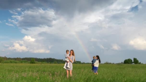 草の上の曇り空と森で虹を見ている子供たちの母親 農村自然景観 — ストック動画