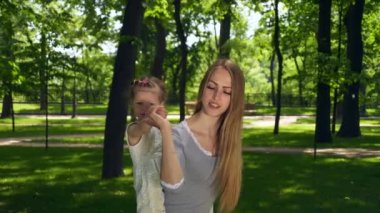 Şehir Parkı 'nda Çocuk Taşıyan Anne' n kutlu olsun. Parlak Güneşli Yaz Günü